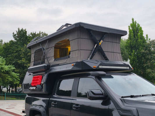 Iron Den Overland all-aluminum slide-in truck camper deployed in pickup bed, rugged pop-up design for overlanding and off-grid camping